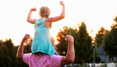 girl on adults shoulders